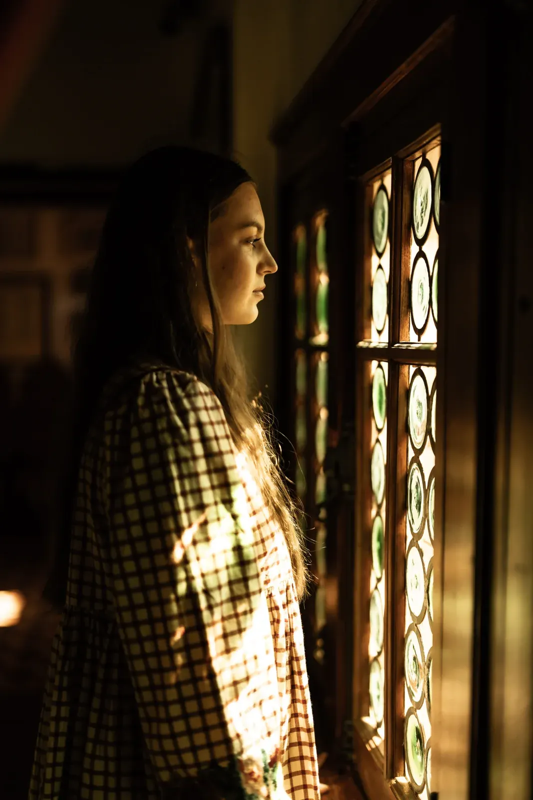 Pauline de profil dans la lumière dorée des vitraux — création d'images.